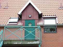 Entréerna till övre våningen i plåtklädda frontespiser, utvändiga trappor leder upp.