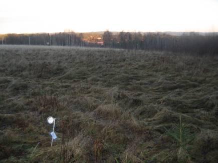 ligger en liten bit nedanför. Loggen står i något lä vid några träd och buskar samt ett uthus strax bredvid (5 meter) (figur 5). Figur 5.
