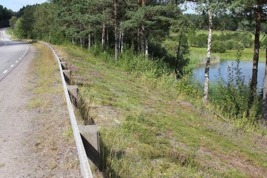 Bild 7 Nuvarande vägslänt ned mot vatten I trängre passager, inom tätorterna där högsta tillåtna hastighet är max 50 km/h, avskiljs GC-vägen med kantstöd.
