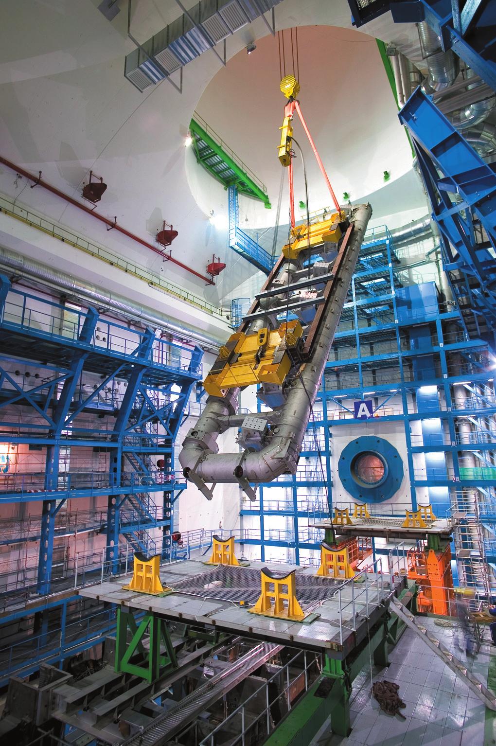 ATLAS-detektorn under uppbyggnad. De första toroidspolarna sänks ner till bergrummet.