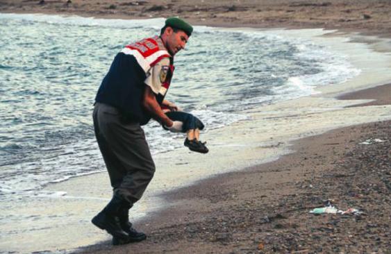 Precis som den beskurna versionen av bild 1 känns stranden ödslig och pojken upplevs vara helt ensam med den hjälpande polismannen. Männen som fiskar, samt den andre polismannen, syns inte i bild.