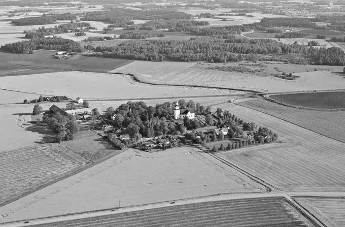 Fig.. Vårdsbergs kyrka ligger högt placerad med vid utblick över den breda dalgången mellan Åtvidaberg och Linköping omgiven av bl.a. sockenstuga och en skolbyggnad.