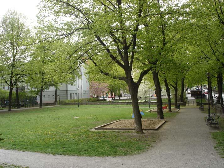 Den västra gården har en stor oval perennrabatt i mitten och parksoffor står i grusgången kring rabatten. Bakom sofforna finns körsbärsträd.
