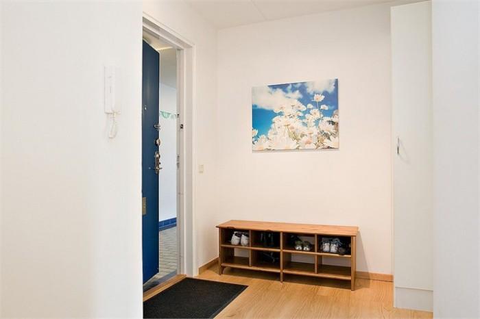 Hall Välkommen in till denna ljusa lägenheten som har genomgående vita väggar och laminatgolv.