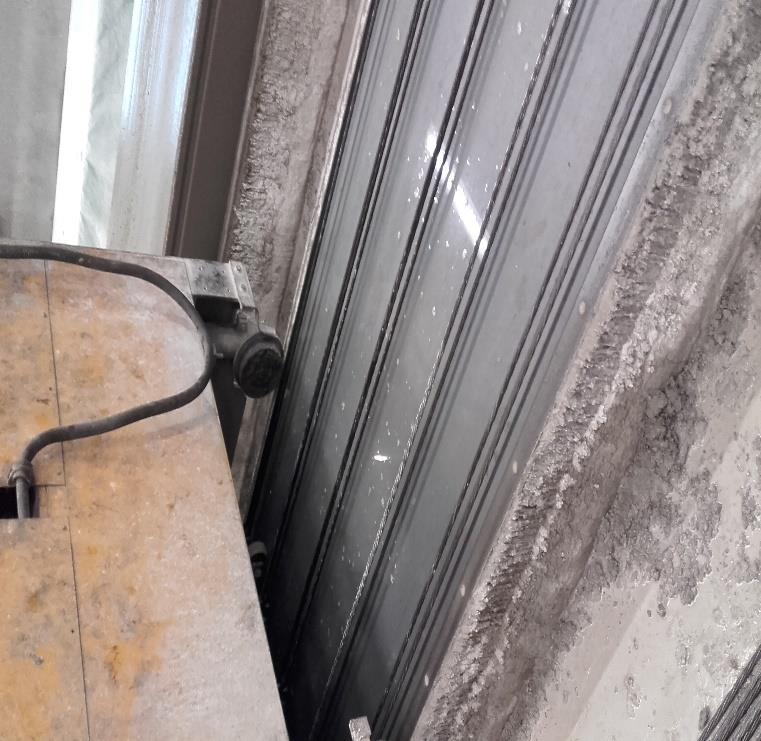 Figur 2.3: Gjutmaskinen och de förspända linorna på formen. Betong blandas på intilliggande betongstation.