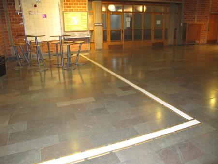 Ledstråk från entré till orienteringstavla i Blackebergs gymnasium. Metallister skall användas till ledstråk. Målade ledstråk slits ut och de kan ej kännas av tydligt med käppen.