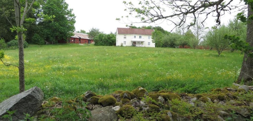 Bevarad traditionell ladugård, samt smidesgrind med namnet