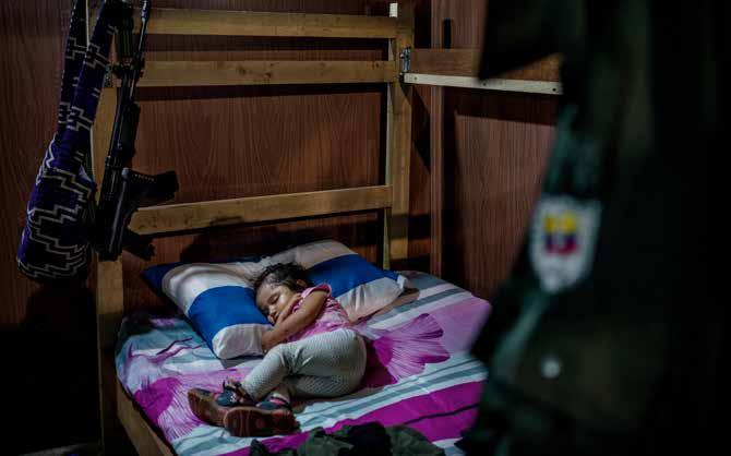 Sara Manuela 2 år sover vid ett vapen och en uniform. FARCsoldaterna tillåts inte skaffa barn, men hennes föräldrar tror på fredsprocessen och beslutade att ta risken.