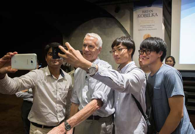 Några studenter tar en selfie med Nobelpristagaren Brian Kobilka under Nobel Prize Inspiration Initiative i Sydkorea.