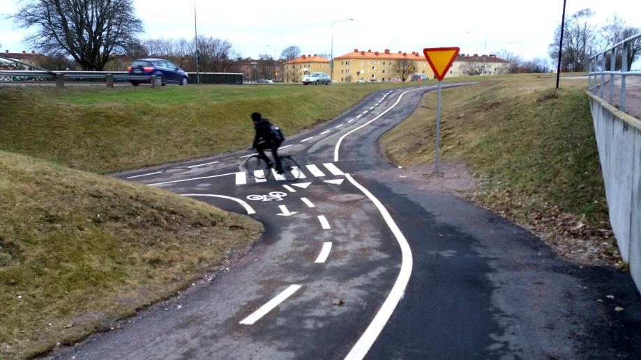 Här vid gång- och cykeltunneln under Gröndalsvägen har kommunen satsat på extra stor tydlighet med tanke på nedförsbacke, skymd kurva, blandning av gångare och cyklister och korsande trafik från tre