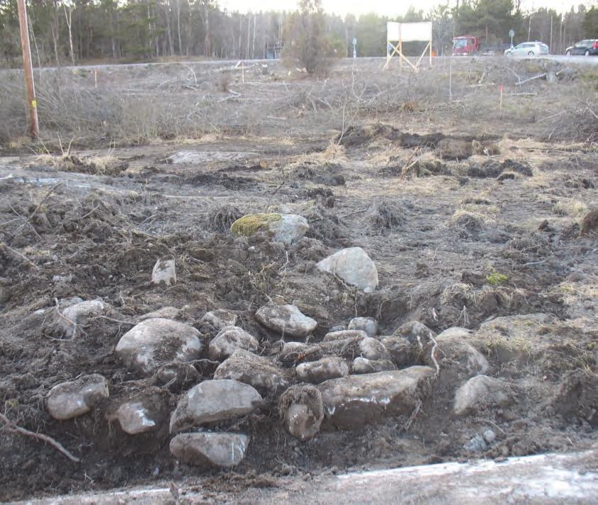 På två punkter hade grävmaskinen vid körning inom området frilagt delar av ett lager med kol och sot inom en yta av ca 7 7 meter. Delar av detta lager frilades och undersöktes genom handgrävning.