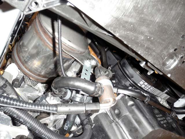 / Demonter platen under motoren. Varmeren monteres på A- siden av motoren. Demonter slangen () fra vannrøret (). Demonter bolten () fra eksosfestet. Monter braketten (4) på varmeren ().