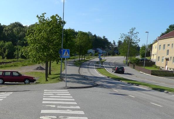 Väg 162 mot Lyekil öder om rondellen. Mittrefugen ger en avmalnande effekt och allén en vi inramning men trot detta upplev gaturummet om brett.