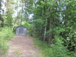 Högre liggande del slänt med mestadels gles vegetation av tallar och en del berg i