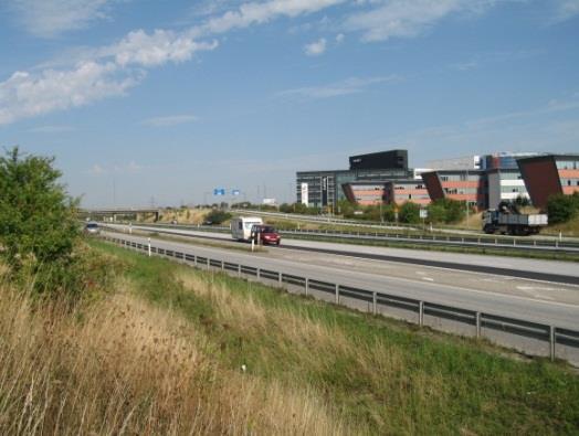 Bebyggelsen intill vägen syns inte på grund av slänter, bullervallar och vegetation. Figur 30 Fotot är taget från norra delen av utredningsområdet i riktning mot trafikplats Lund Norra.