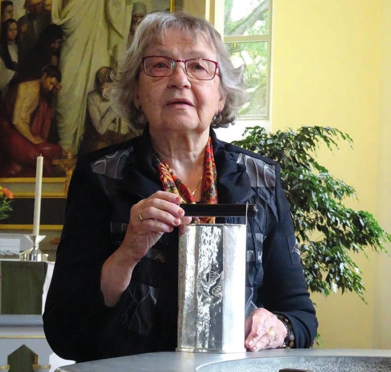 På bilden håller Eeva den vackra dopkannan som hon skänkte till Fågelfors kyrka vid sin avgång som kyrkvärd. Kyrkvärd Och det har du varit i femton år?
