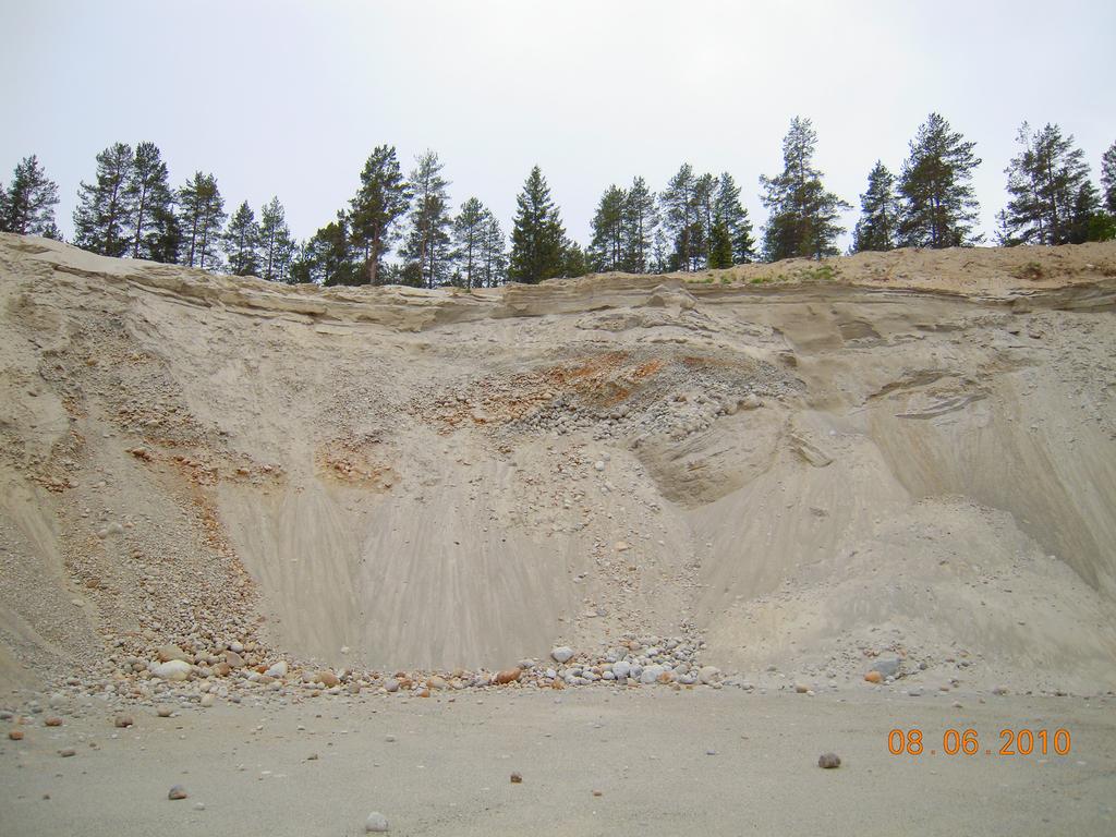 Figur 10. Stenigt isälvsgrus med över- och inlagrad isälvssand i Skorpedsåsen nära Mjälamogården. Överst i lagerföljden, uppe till höger i bilden, syns överlagrande svallsediment.