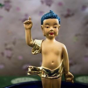 Statyer av Buddha som liten bärs fram. Vänner och släkt samlas och äter gott tillsammans.
