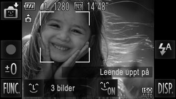 Välj genom att peka på den och peka sedan på ^. Rikta kameran mot en person. Varje gång kameran upptäcker ett leende tar den en bild efter att lampan tänts. Peka på om du vill pausa leendefunktionen.