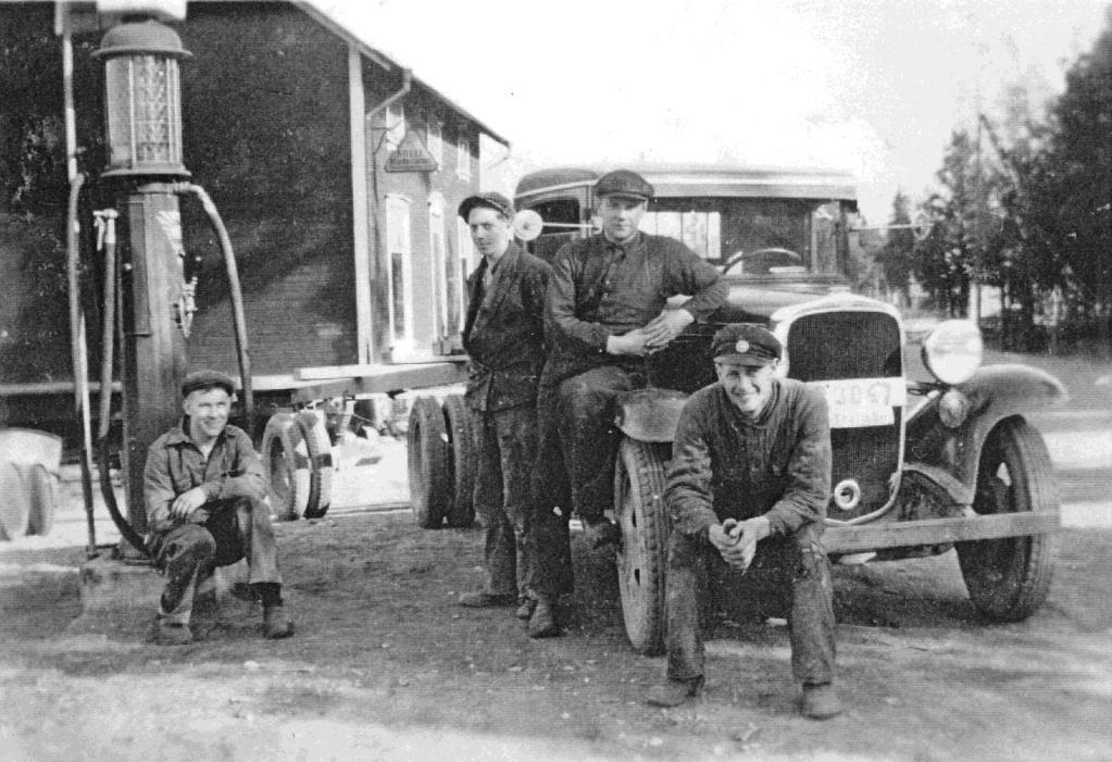 Gulfmacken Karl Johansson sitter vid företagets första bensinpump. Bredvid honom står en okänd man, därefter Gunnar och Gerhard Carlsson. Foto från omkring 1940.