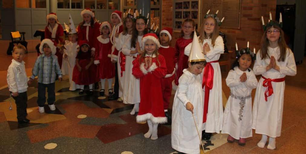 Ett ivrigt luciatåg står och väntar på att få göra entré. De ska sjunga julsånger för både föräldrar och utlandsgäster som samlats till BFAs julfest i Göteborg.
