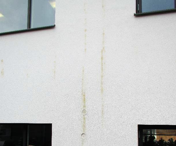 Bild 1.1 Missfärgad fasadputs med bakomliggande skivor och luftspalt. Foto: Byggeskadefonden Danmark [2]. En studie undersöker bl.a. magnesiumoxidskivors fuktbetingade rörelser.