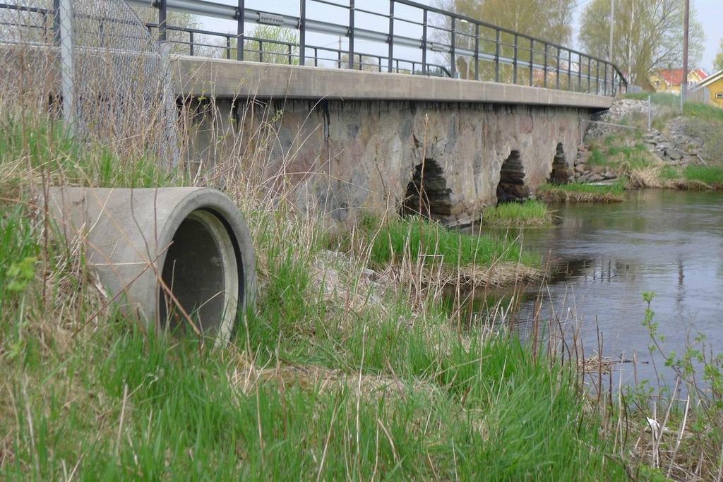 F75: betongtrumma vid äldre stenbro, med markeringsstenar och