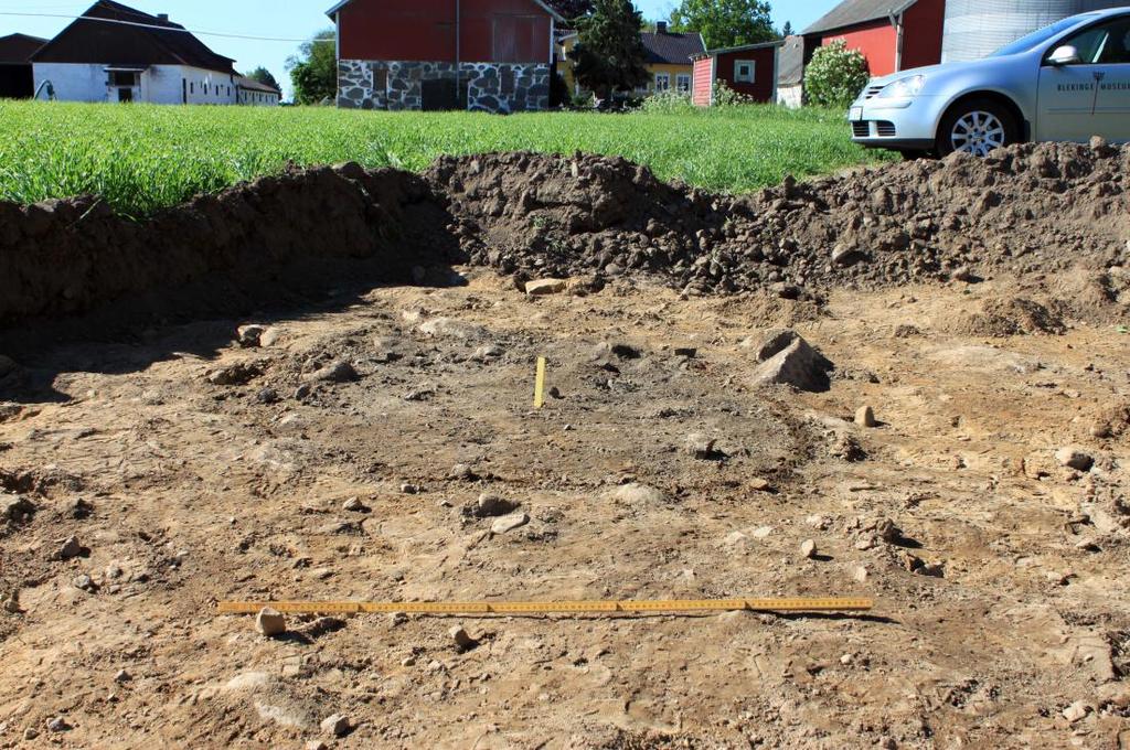 I Schakt 13, nära Stensborgs gård, påträffades däremot en av plogen ganska hårt åtgången fynd- och anläggningsförande nivå 0,35 m under dagens markyta.