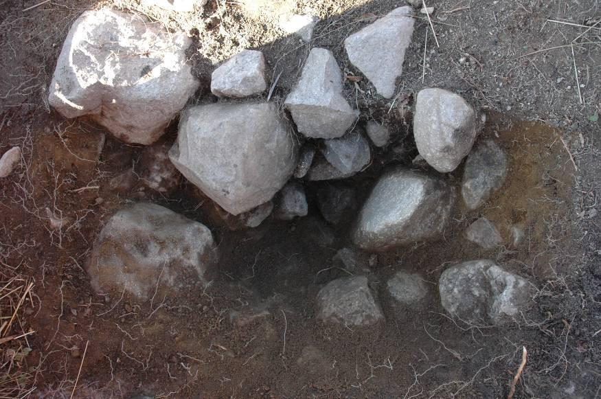 Stolphål nr 2 överlagrades av stenraden som låg i ett ca 0,1 m tjockt lager grus/morän. Direkt Ö om stolphål nr 2 fanns en sotfärgning (rensades inte fram helt), även denna överlagrad av morängrus.