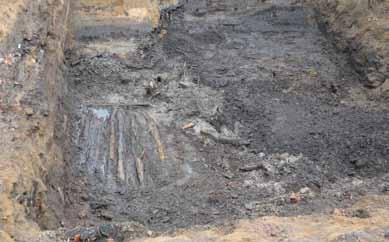 ARKEOLOGISK RAPPORT 2015:45 13 Figur 11. Rustbädden som framkom inom schakt 5 med slanorna liggande i öst-västlig riktning i den sydöstra delen av schaktet. Foto från öster. under förundersökningen.