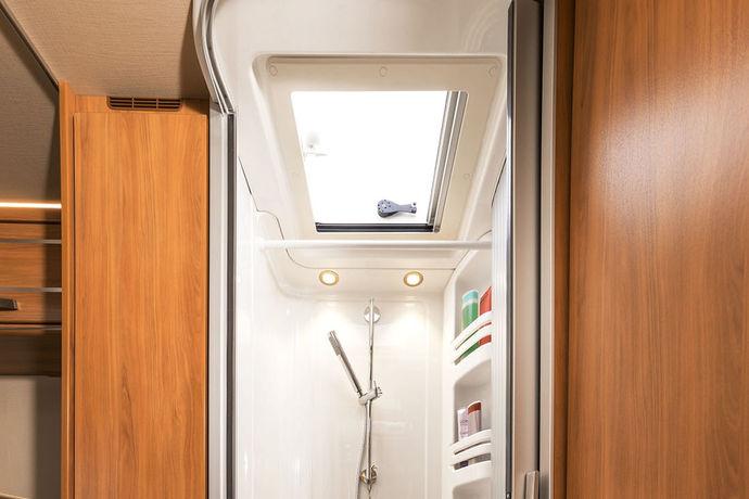 Över den separata duschen i salongsbadrummet i HYMER Tramp SL 704 Ambition ger HYMERtakfönstret med mjölkfärgat glas (standard) god ventilation i duschen och släpper samtidigt in dagsljus i rummet.