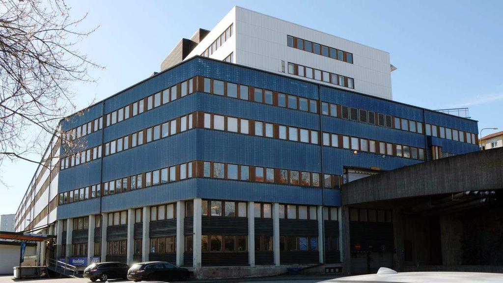 Vandenbergh 9 med sin karaktäristiska fasadindelning med vit och blå plåtkassetter varvat med bruna fönsterband. Här sedd från Bällstaåvägen i norr.