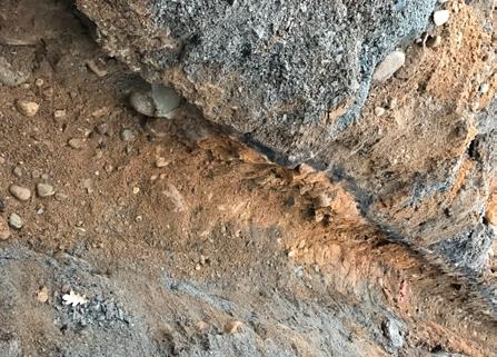 Arkeologgruppen AB rapport 2017:16 A2 var ett 0,08 meter tjockt lager som bestod av svart, sotig sand med inslag av kol.