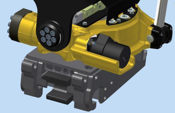 Figur 5.CAD-modell som visar fästet (grått) monterat under rotatorn (gult) 3.1 QSD Det granskade fästet är ett nyutvecklat unikt redskapsfäste som i skrivande stund lanserats på marknaden.