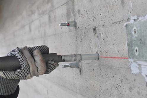Some adhesive was added between the concrete and stretched CFRP using a putty knife. It added perhaps 15 minutes after the pre-stressing work was finished.