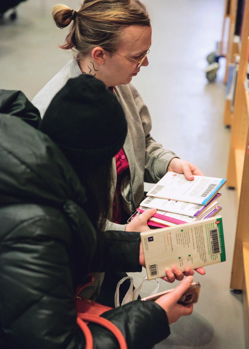 Aseel Abbas informatör på SHK visar biblioteket för nyanlända.