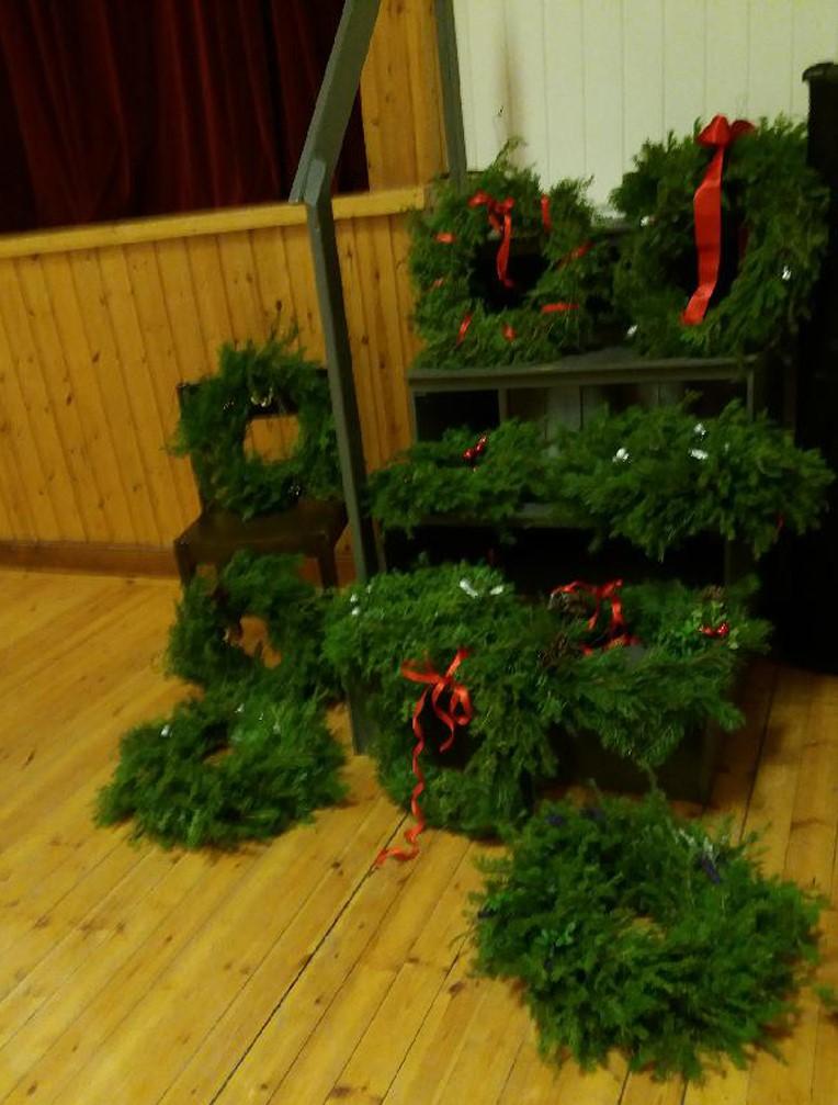 Julkransar Flitens lampa lyste över folkets hus, flinka kvinno händer gjorde jättefina julkransar till julmarknaden.