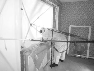 Fönsterskydden hölls på plats genom att stöttor riggades upp mellan golv och tak i rummet innanför fönstret varefter spännband monterades mellan fönsterskydd och stöttor.