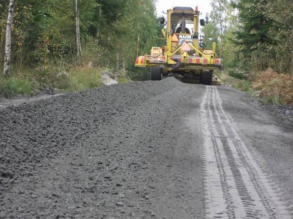 a Figur 10 Avjämning av flygaska (a) och utläggning av grusmaterial (b). Figure 10 Levelling of fly ash (a) and tipping of gravel on the road (b).