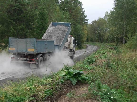 a Figur 12 Utläggning av flygaska med grusbil (a) och packning med vibrovält (b). Figure 12 Tipping of fly ash from a gravel truck (a) and compaction of the road (b).