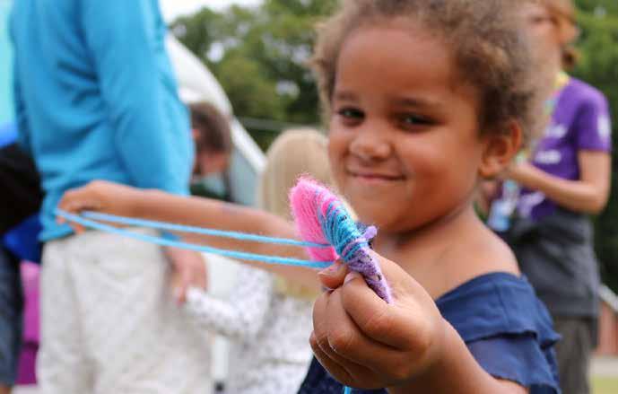 Luna Johnsen gör en garnboll när Biblioteksbussen ordnar pyssel verkstad på Malmöfestivalen.