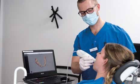 Henrik och Sara demonstrerar en intraoral scanner. Scannern tar ett digitalt avtryck av Saras tänder. hur betalkiosken fungerar. Brainstorming.
