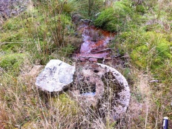 Brunnen ligger bredvid skogsvägen på vänstra bilden. På högra bilden visas brunnen.