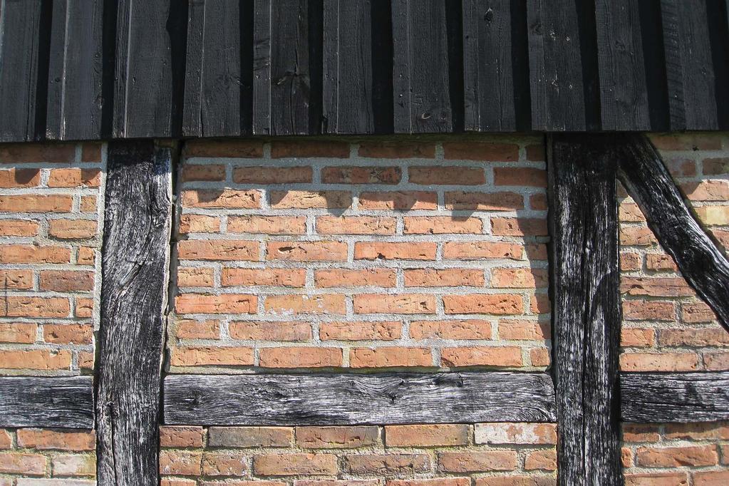 Tegelfyllning i östra längans södra gavel vilken lutar inåt och har kilats från insidan.