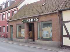 fastighet: LOVISA 7. adress: Stora Norregatan 15. ålder: 1800-tal. Ombyggt 1953. arkitekt / byggm: Bertil Sandin (1953). användning: Affär. antal våningar: 1 Grå cement.