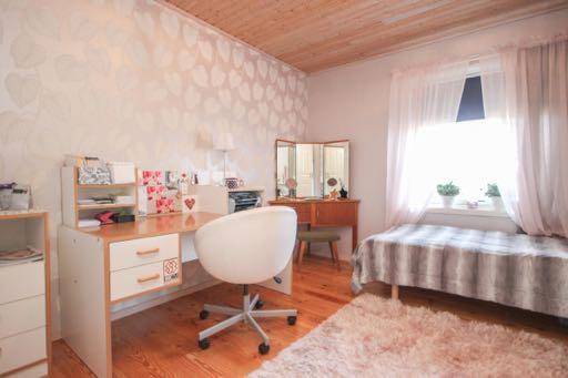 Tapetserade väggar i beige ton, mörkbetsade (fusk)balkar i tak med belysning förstärker den rustika känslan.