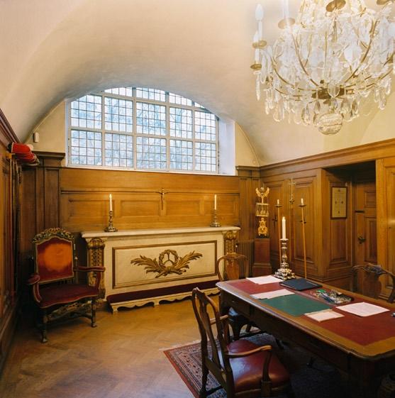 8 hedvig eleonora kyrka kannelerade, grågrönt marmorerade träkolonner. Brädgolvet är betsat och bänkarna av trä är marmorerade. Över läktarna hänger malmkronor.