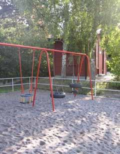 I parkens norra del finns en lekplats med en rosamålad klätterborg och en gungställning i en yta av strid sand.