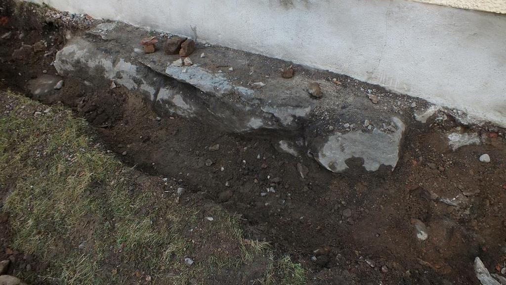 F- Trappfundament Under långhusets västra fönster i den södra fasaden syntes vid markytan en stor stenhäll, liggande i byggnadskroppens längdriktning, dvs öst-väst.