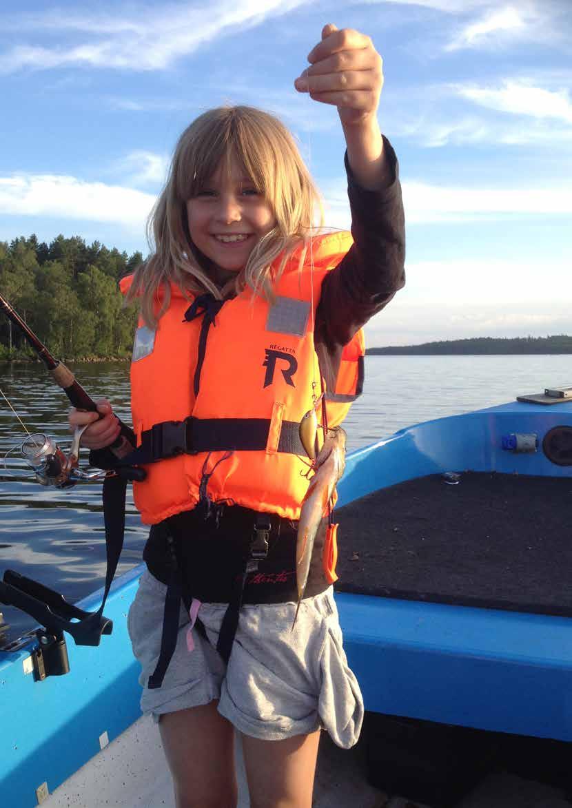 Lycklig fiskarflicka med abborre